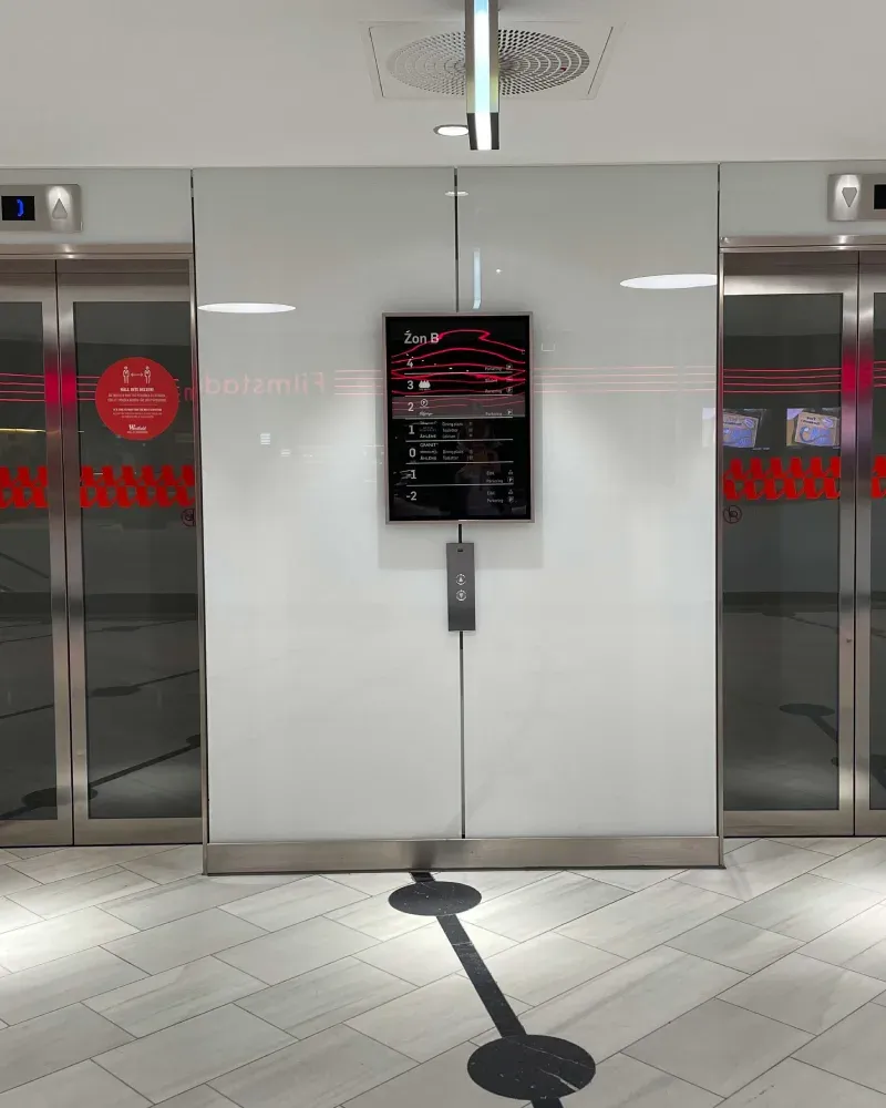 Två hissar med rostfria omfattningar i ljus vägg, Mall of Scandinavia